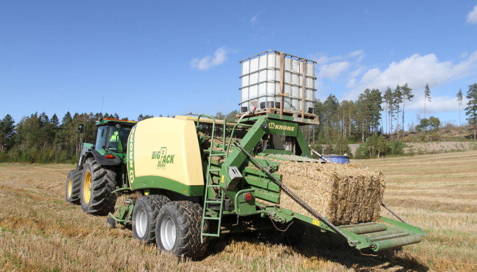 Krone firkantpresse i gang med å presse halm på et jorde i Akershus.