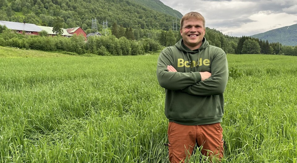 Harald Bjørnsen er siste husdyrbonde i bygda, men det tar ikke humøret fra ham. Harald Bjørnsen fra Bardu poserer smilende midt ute i enga.