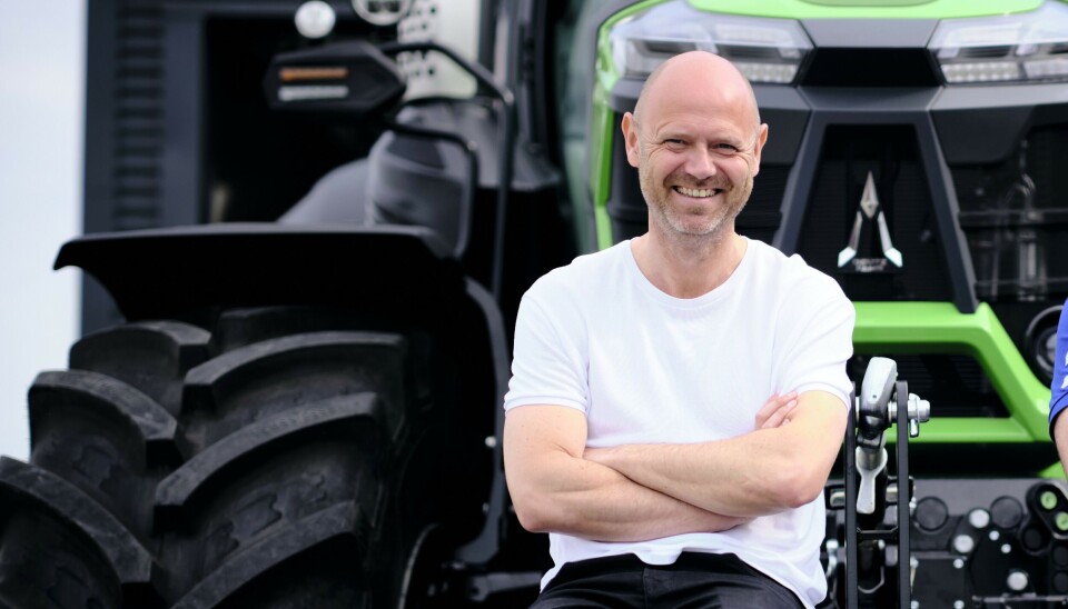 Henrik Hansen, administrerende direktør i Moni Woeldwide. Henrik Hansen, administrerende direktør i Moni Woeldwide, lener seg smilende mot en Deutz-Fahr traktor.