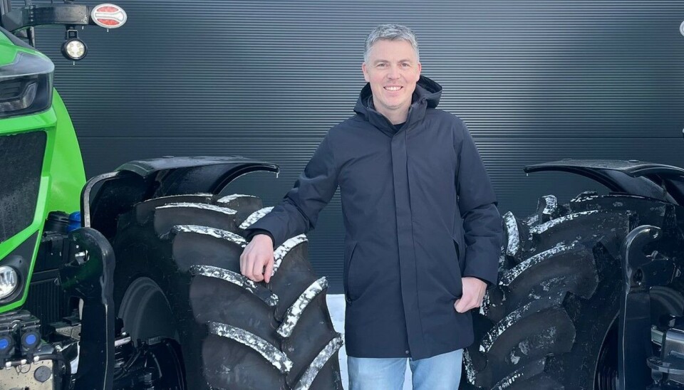 Jo Kjetil Sæther får ansvaret for servicen i Deutz Fahr Norge. Jo Kjetil Sæther poserer smilende mellom to traktorer.
