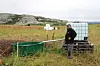 Jon Nikolaisen fyller vann i et plasttrau på beitet på garden i Finnmark.