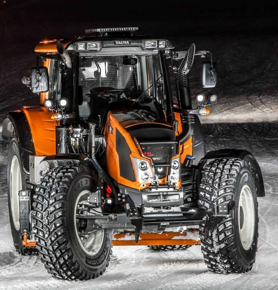 En oransje Valtra Unlimited traktor i snøen.