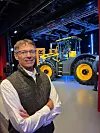 John Smith med en JCB Fastrac traktor i bakrunnen.