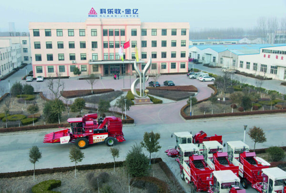 Et dronebilde av fabrikkområdet til Jinyee i Kina med flere store, røde høstemaskiner parkert der.