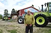 Ole Gjermundshaug poserer på gardsplassen med flere traktorer i bakgrunnen.