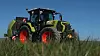Claas Arion 6.190 med rundballepresse bak kjørende på et jorde med gras i forgrunnen