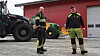 Kristian Ugedal (t.v.) og Elias Moan foran en rød driftsbygning med to traktorer i bakgrunnen