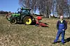 Olav Håkon Ulfnes foran en lett John Deere med tvillinghjul og autostyring, påmontert en seks meter brei Einböck.