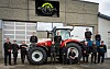 De ansatte hos Jone Ognedal AS poserer rundt en Steyr traktor utenfor bygningen
