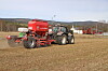 Såmaskin og traktor på jordet.