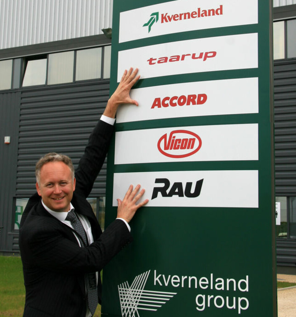 Arild Gjerde foran skiltet med alle merkevarenavnene utenfor Kverneland.