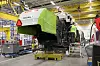 En skurtresker av typen Claas Tucano blir montert i en fabrikkhall.