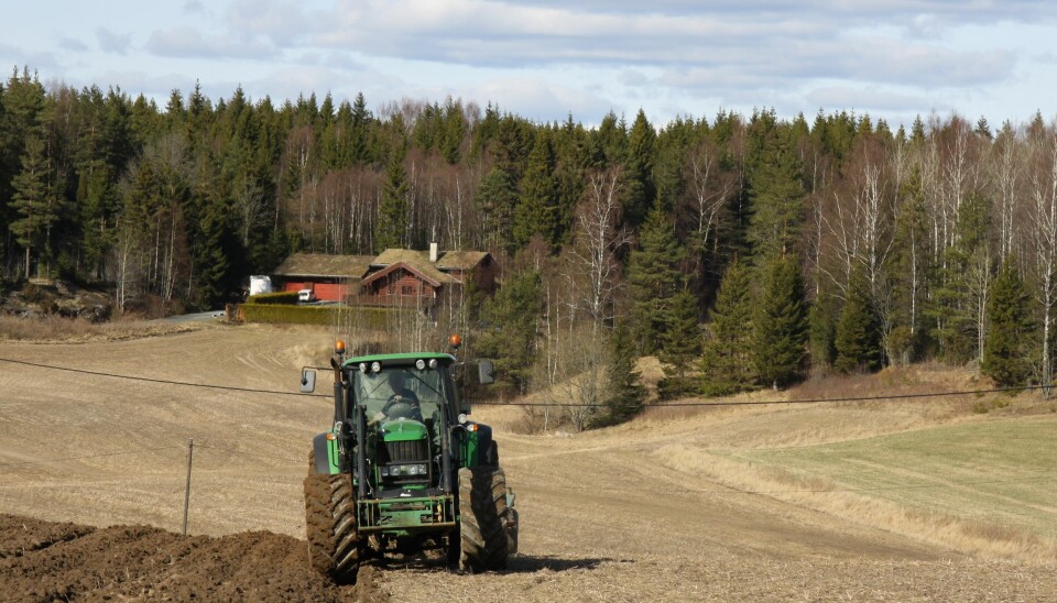Traktor i gang med å vårpløye et jorde i Østfold.
