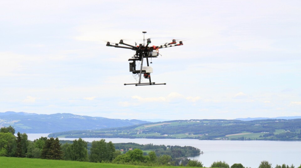 Stor drone brukt i forskning på Nibio Apelsvoll fotografert i lufta med Mjøsa i bakgrunnen.