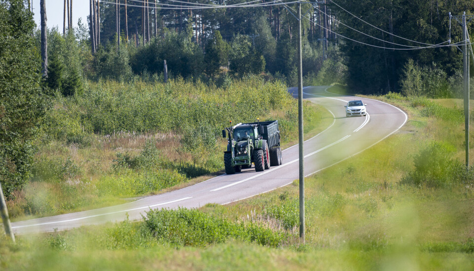 Traktor med henger kjører på veien i Finland.