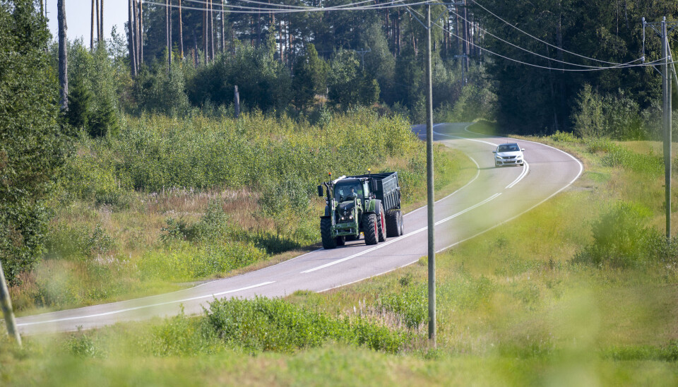 Traktor med henger kjører på veien i Finland.