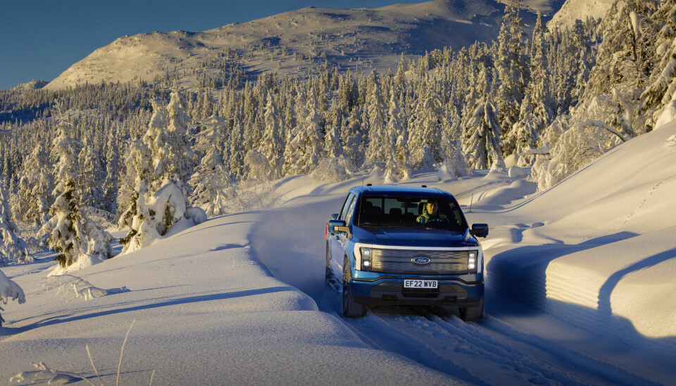 Pickup kjører på snødekt veg.