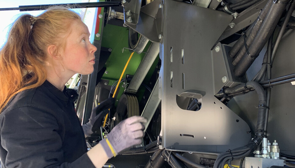 Marthe, mekankinerlærling, i gang under dekslet på en Fendt-tresker.