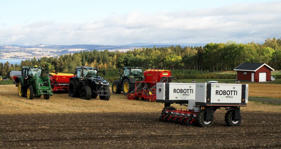 Robot på et jorde med traktorer i bakgrunnen