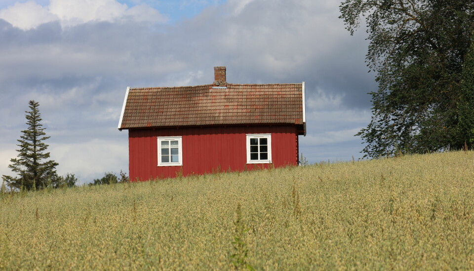 Lite rødt hus på i en kornåker
