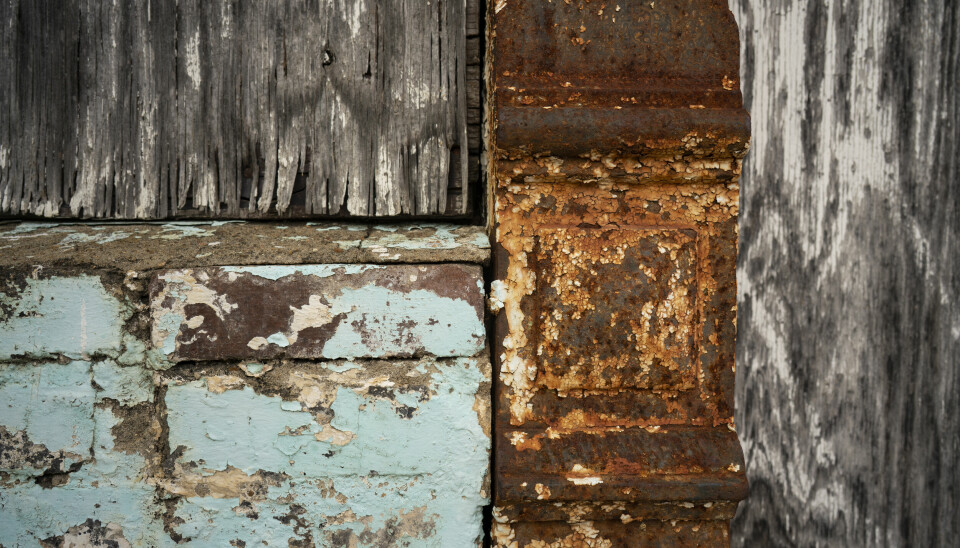 En kombinasjon av gammelt treverk, eldre mur med avflassende maling og rustent metall