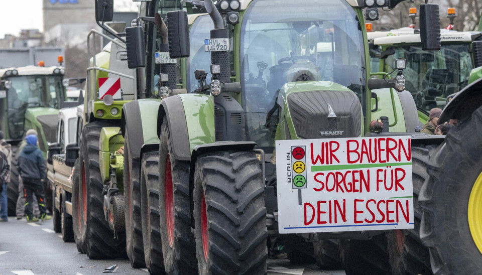 Traktorer fyller gatene i Berlin mandag 15. januar. En parkert Fendt har et skilt i front med teksten: 'Vi bønder sørger for maten'